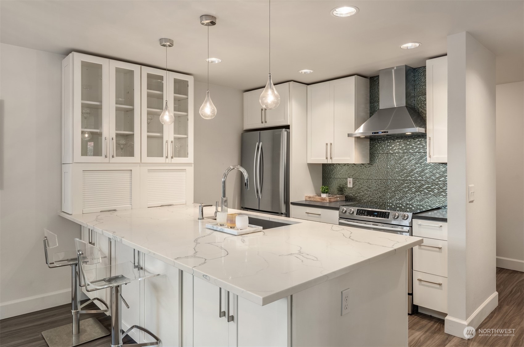 a kitchen with granite countertop a sink a center island stainless steel appliances and cabinets