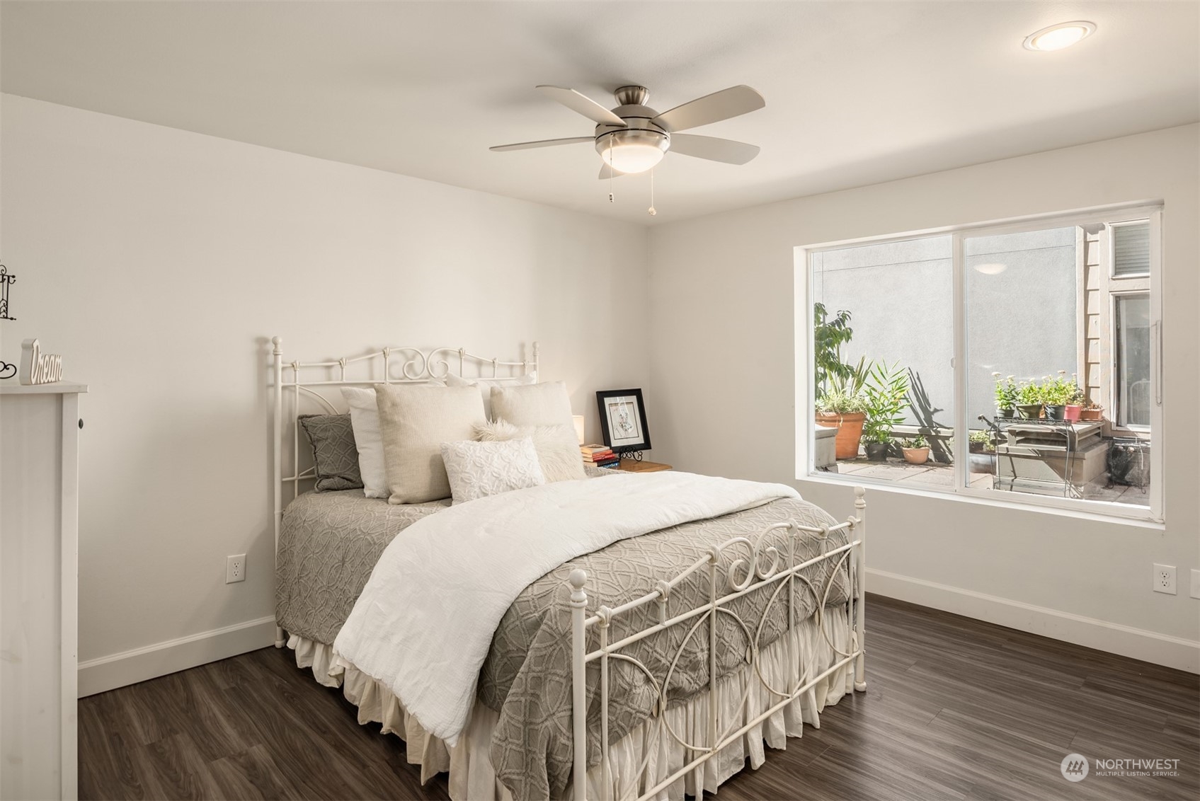 500 Aloha Street, Unit E111 Seattle, WA 98109 - Photo 17 of 25 a bedroom with a bed and a large window with wooden floor