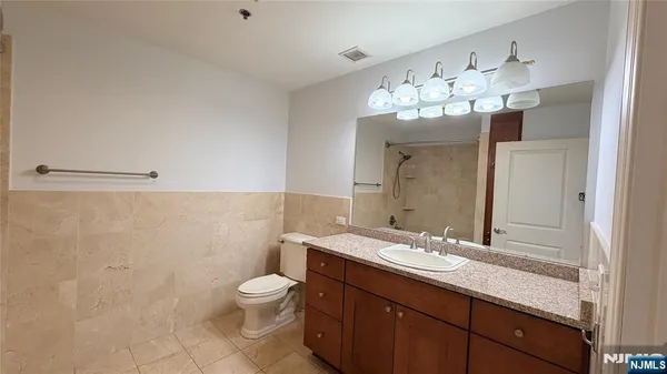 a bathroom with a double vanity sink mirror and toilet