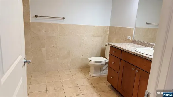 a bathroom with a granite countertop toilet and a sink