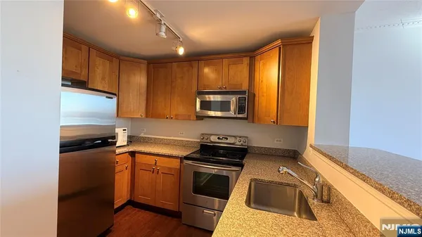 a kitchen with granite countertop a stove a sink and a microwave