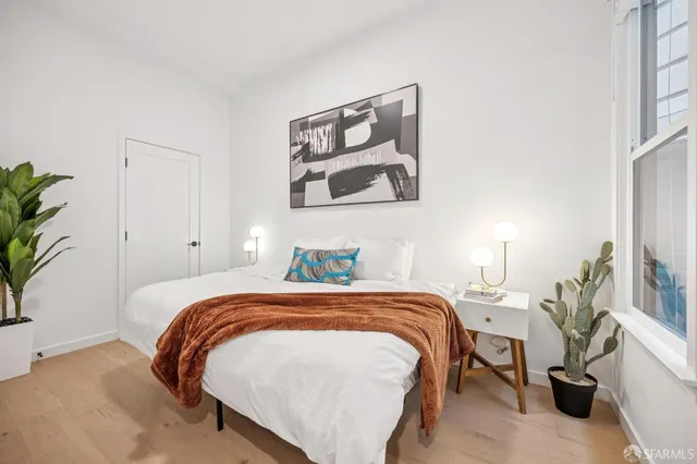 a bedroom with a bed and a potted plant