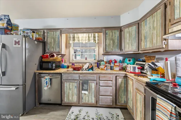 a kitchen with stainless steel appliances granite countertop a refrigerator sink stove and cabinets