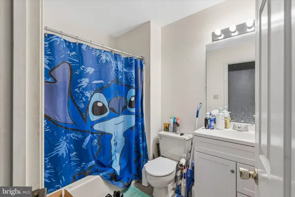 a bathroom with a toilet a sink and a shower curtain