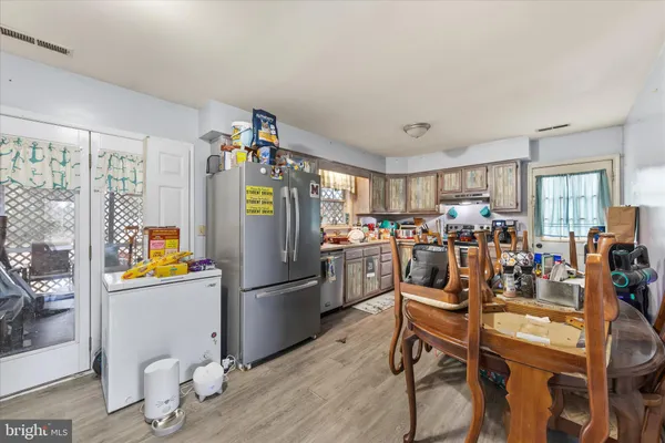 a kitchen with stainless steel appliances a refrigerator a stove a dining table and chairs