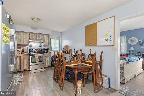 a view of a dining room with furniture a kitchen and chandelier