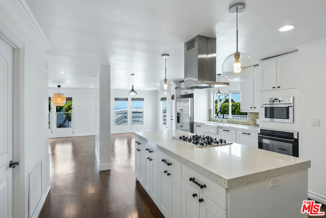 a kitchen with stainless steel appliances kitchen island granite countertop a sink a stove and cabinets