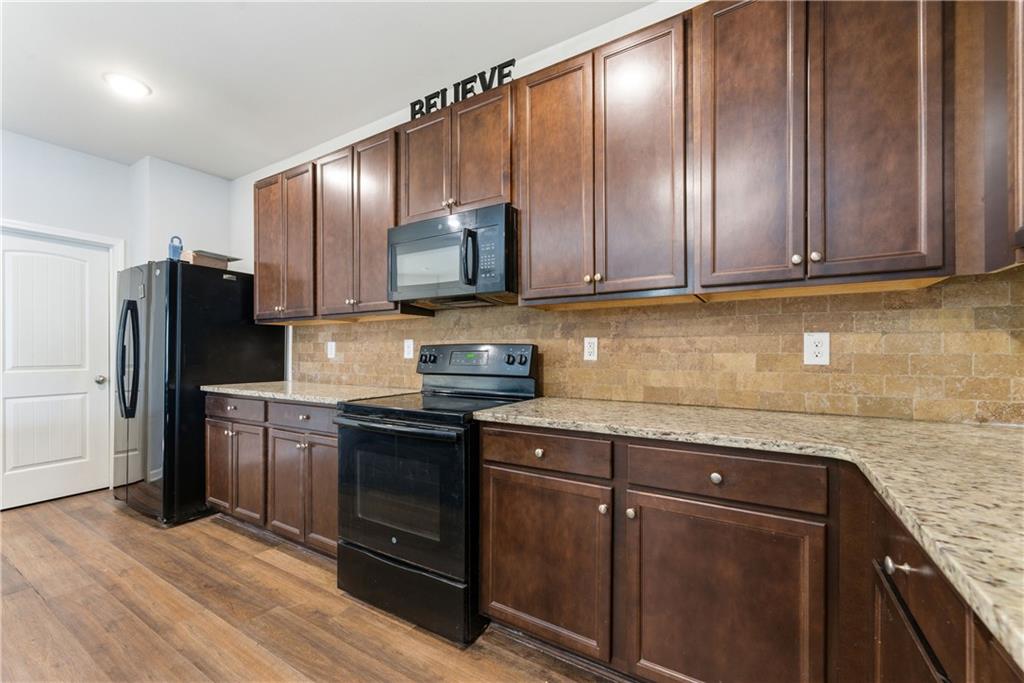 6771 Mason Lane Rex, GA 30273 - Photo 12 of 30 a kitchen with granite countertop wooden cabinets a refrigerator and a sink