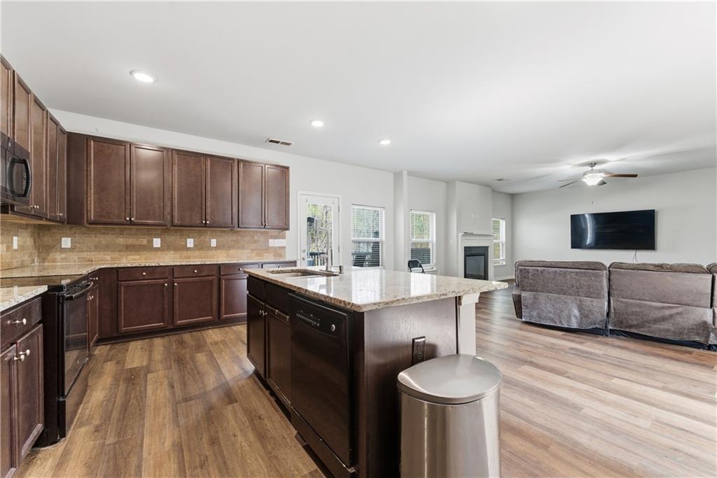 6771 Mason Lane Rex, GA 30273 - Photo 16 of 30 a kitchen with stainless steel appliances granite countertop a stove top oven a sink dishwasher and cabinets with wooden floor