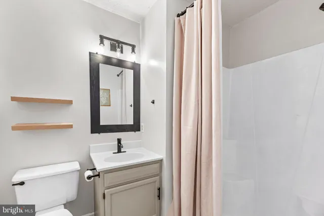 a bathroom with a sink a toilet and a mirror