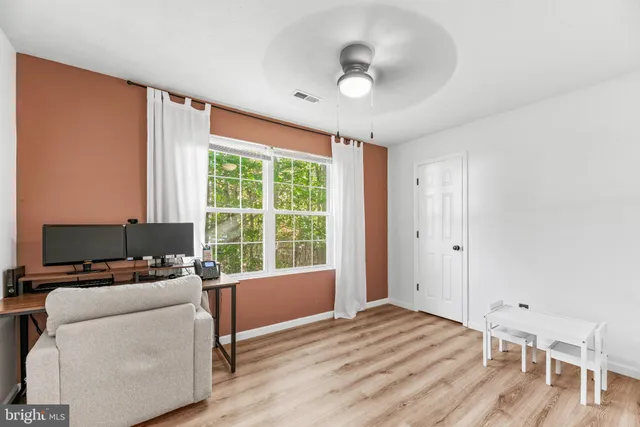 a view of a workspace with furniture and a window