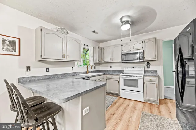 a kitchen with stainless steel appliances granite countertop a white cabinets and a stove