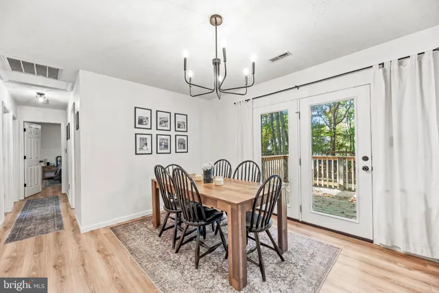 a dining room with furniture a chandelier and wooden floor