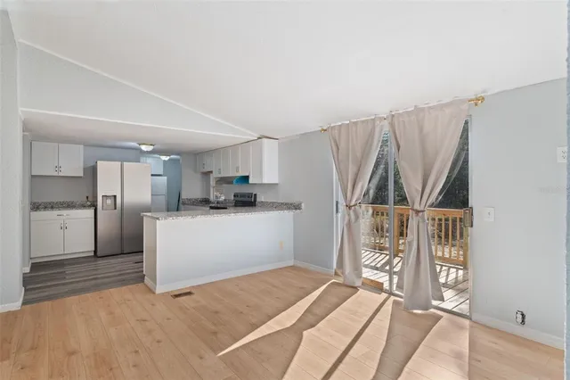 a kitchen with white cabinets and refrigerator