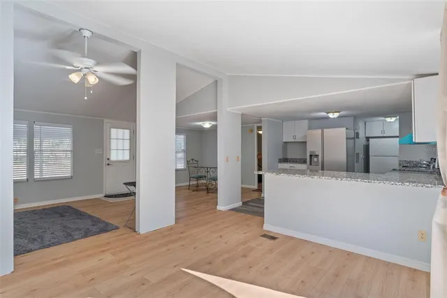 a view of a living room and kitchen with wooden floor