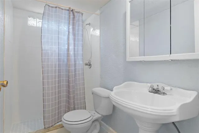 a white toilet sitting next to a bathroom sink
