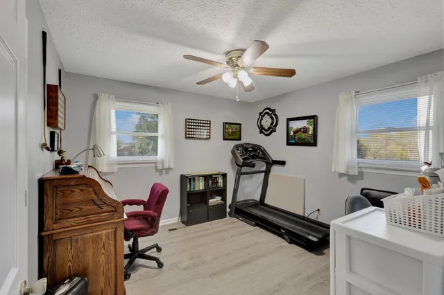 a view of a workspace with furniture and a window