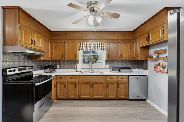 a kitchen with a sink cabinets stainless steel appliances and a window