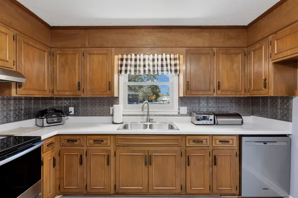 a kitchen with stainless steel appliances granite countertop a sink stove and cabinets