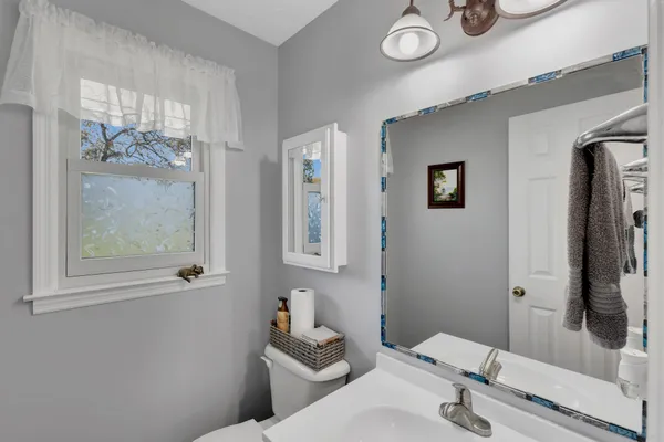 a bathroom with a toilet sink a mirror and a shower