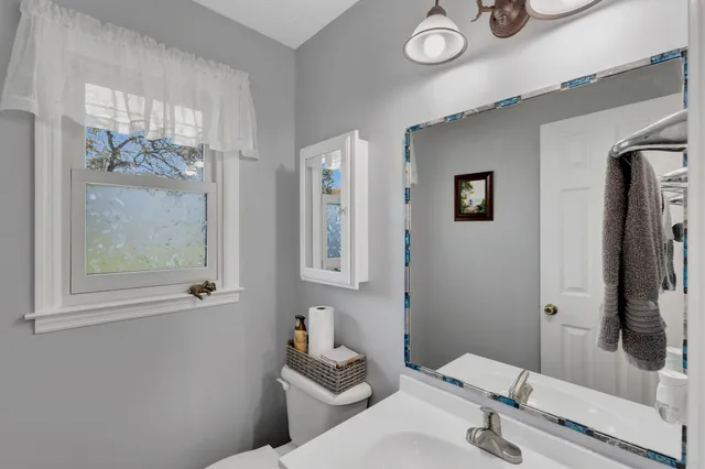 a bathroom with a toilet sink a mirror and a shower