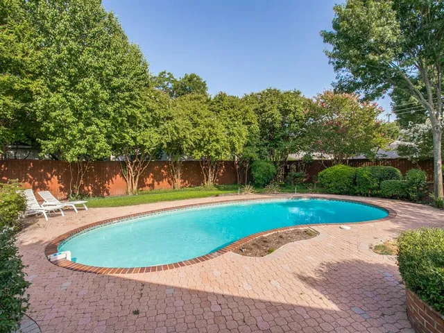 a view of a swimming pool with a yard