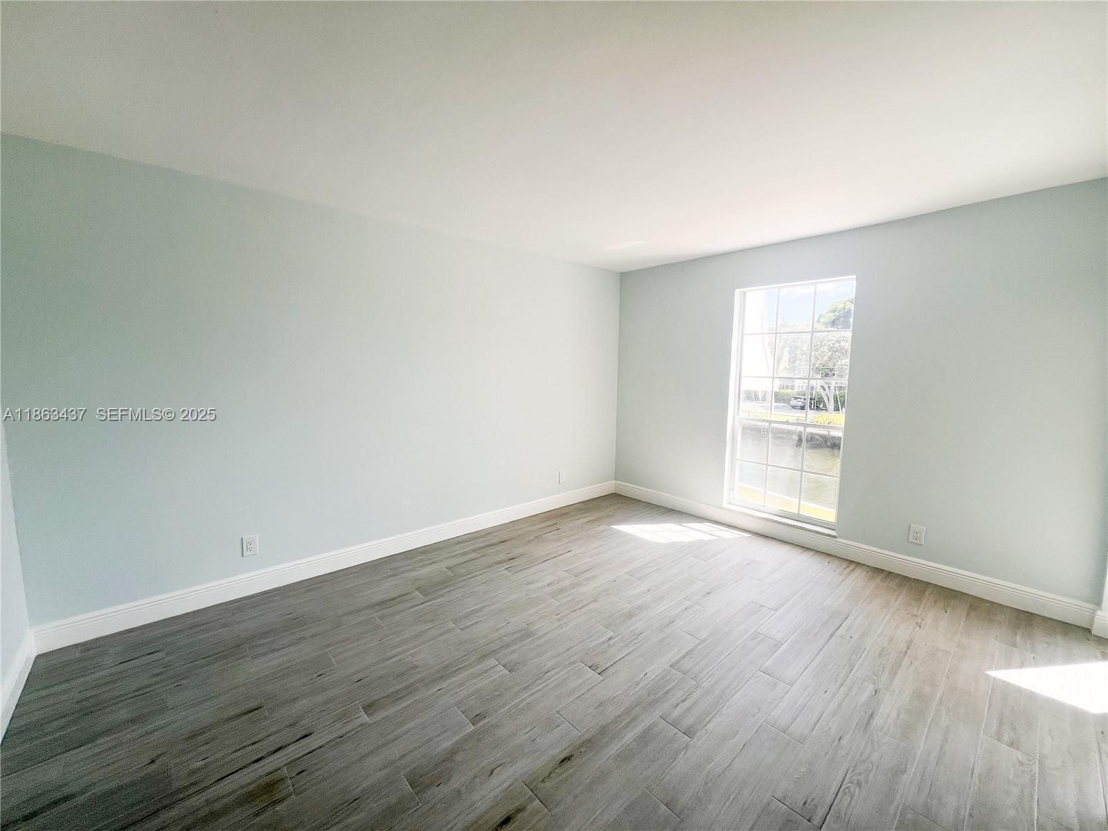 769 Jeffery Street, Unit 2205 Boca Raton, FL 33487 - Photo 12 of 30 an empty room with wooden floor and windows