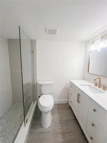 a bathroom with a toilet sink and a mirror