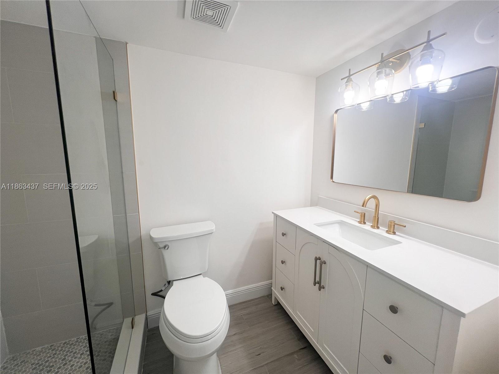 769 Jeffery Street, Unit 2205 Boca Raton, FL 33487 - Photo 18 of 30 a bathroom with a toilet sink and mirror