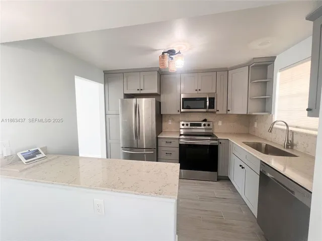 a kitchen with granite countertop a refrigerator sink and stove