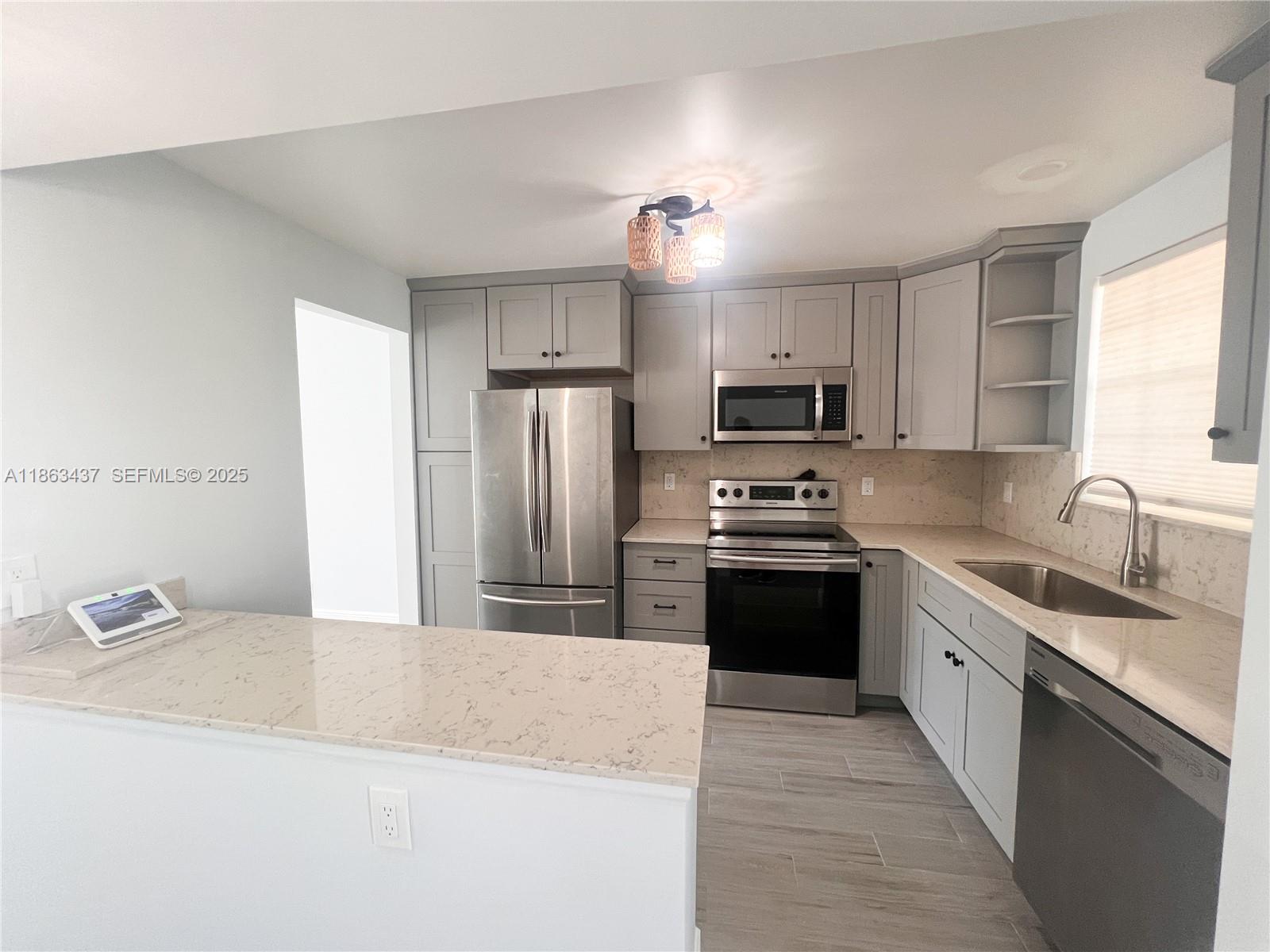 769 Jeffery Street, Unit 2205 Boca Raton, FL 33487 - Photo 2 of 30 a kitchen with granite countertop a refrigerator sink and stove