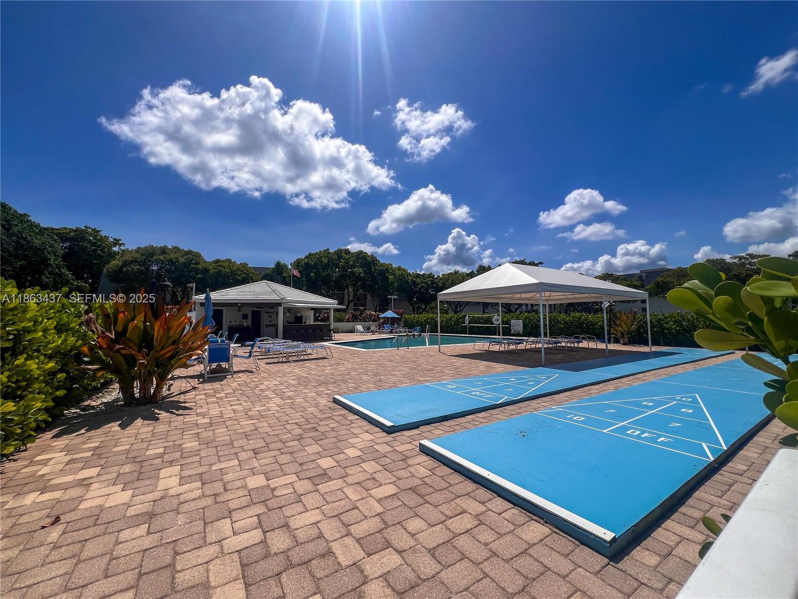 769 Jeffery Street, Unit 2205 Boca Raton, FL 33487 - Photo 28 of 30 a view of a yard with a table and chairs under an umbrella