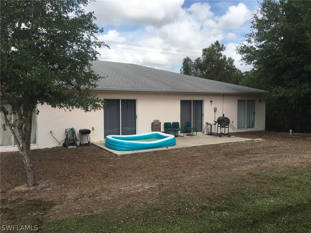 941 Homestead Road South, Unit 941/943 Lehigh Acres, FL 33974 - Photo 19 of 19 a view of a house with backyard and porch