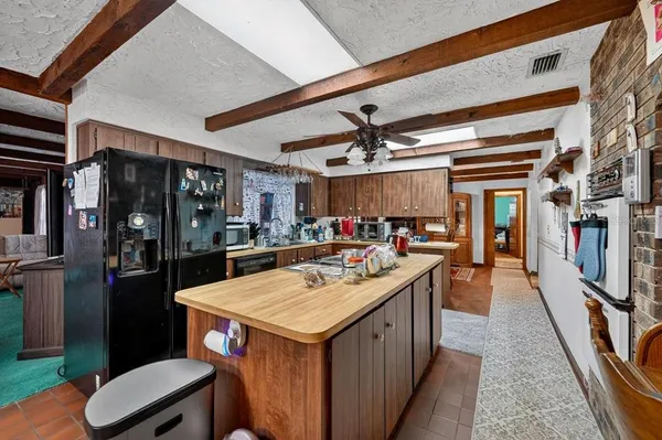 a kitchen with a sink a counter space appliances and cabinets