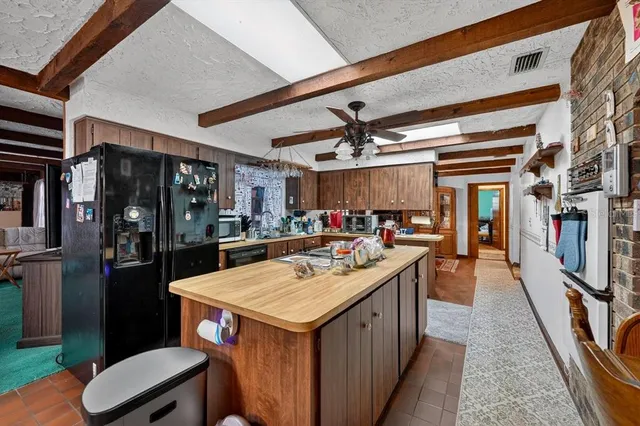 a kitchen with a sink a counter space appliances and cabinets