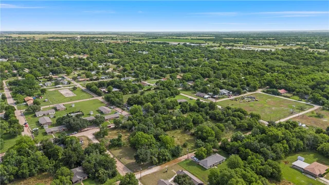 an aerial view of residential houses with outdoor space and trees