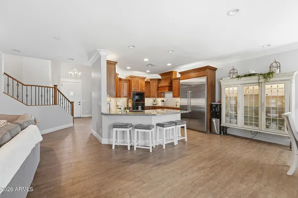 a kitchen with stainless steel appliances granite countertop a refrigerator a sink dishwasher a stove and a oven with wooden floor