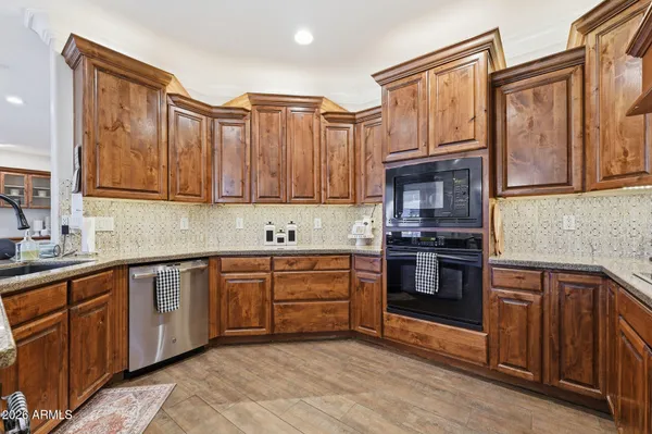 a kitchen with stainless steel appliances kitchen island granite countertop a refrigerator stove and sink