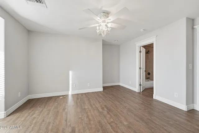 a kitchen with stainless steel appliances granite countertop a stove top oven a sink a dining table and chairs with wooden floor