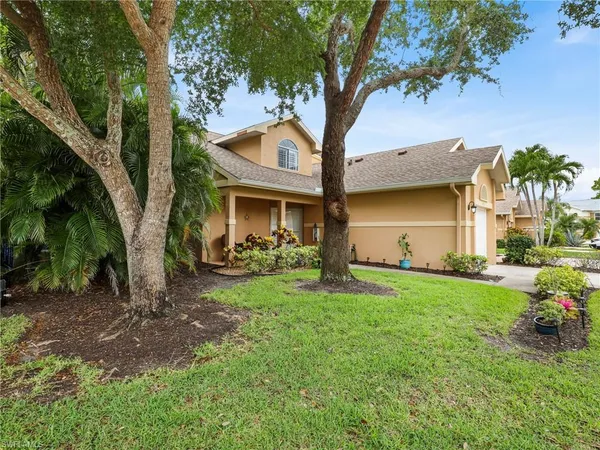 a view of a yard in front of a house with large tree
