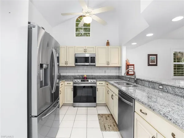 a kitchen with stainless steel appliances granite countertop a refrigerator sink and stove