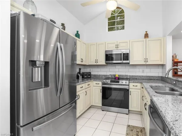 a kitchen with stainless steel appliances granite countertop a stove a refrigerator and a microwave