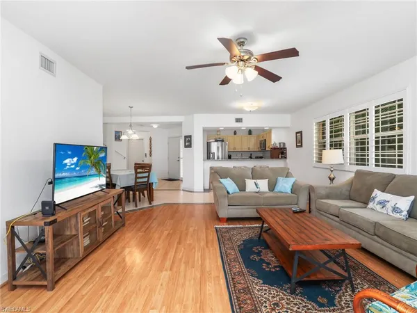 a living room with furniture a flat screen tv and a table
