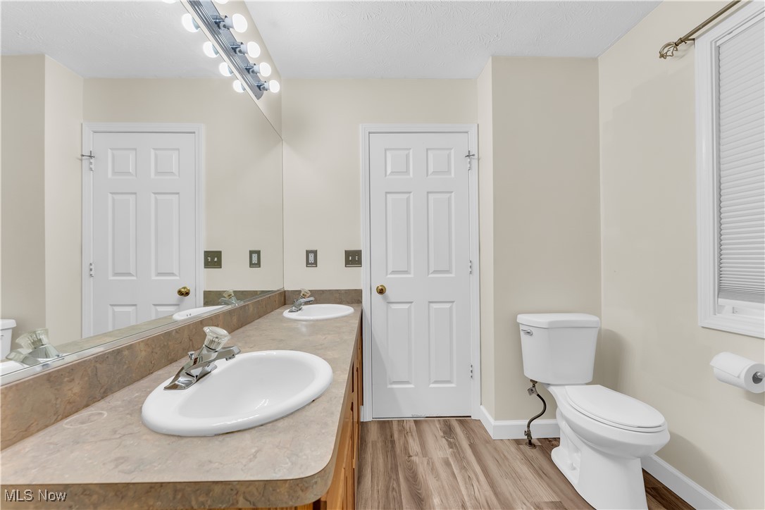 25861 Kennedy Ridge Road North Olmsted, OH 44070 - Photo 21 of 24 Full bath with toilet, double vanity, wood finished floors, and baseboards