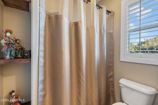 a spacious bedroom with a bed a table and bookshelf