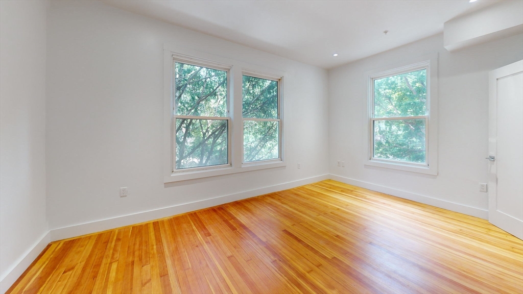 21 Regent Circle, Unit 3 Brookline, MA 02445 - Photo 14 of 21 a view of an empty room with wooden floor and a window