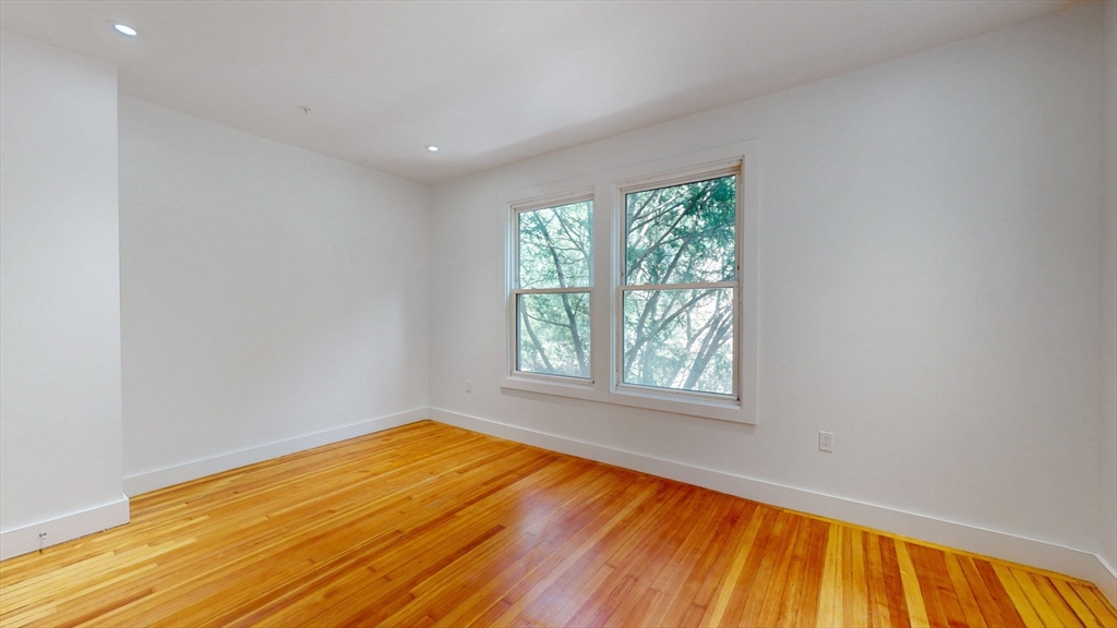 21 Regent Circle, Unit 3 Brookline, MA 02445 - Photo 19 of 21 an empty room with wooden floor and windows