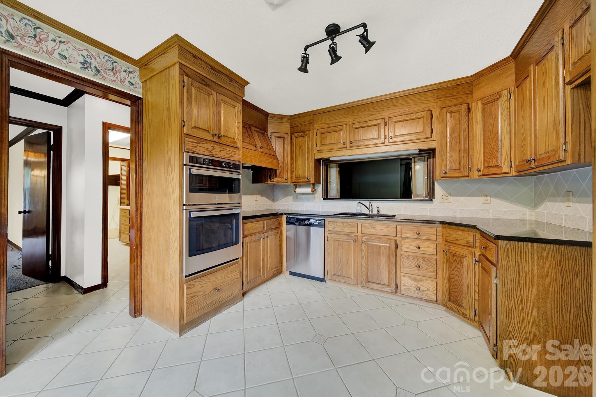 5913 Tom Query Road Charlotte, NC 28213 - Photo 11 of 47 a kitchen with stainless steel appliances a stove a microwave and a sink