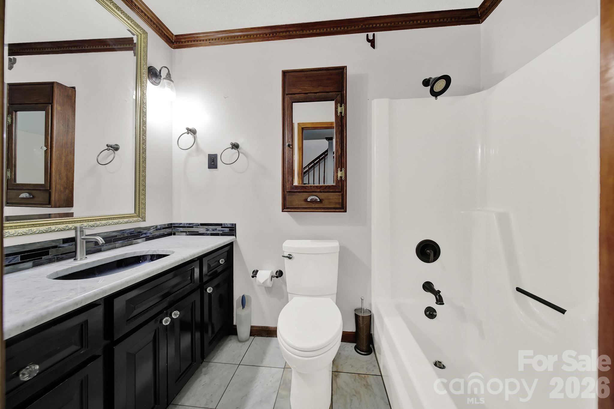 5913 Tom Query Road Charlotte, NC 28213 - Photo 15 of 47 a bathroom with a sink a toilet and shower