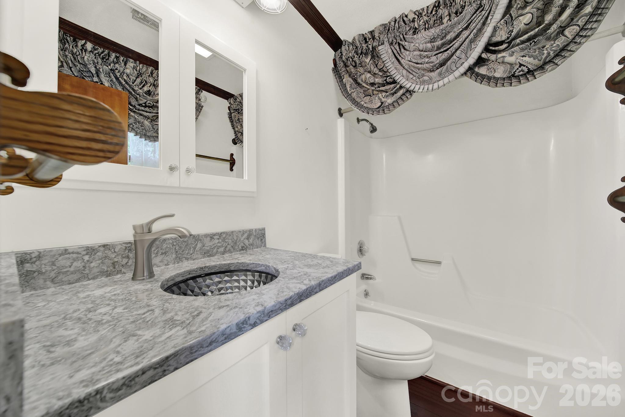 5913 Tom Query Road Charlotte, NC 28213 - Photo 18 of 47 a bathroom with a granite countertop sink a toilet and bathtub
